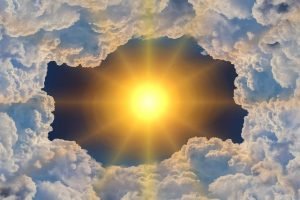 The sun timidly shines through a hole in the clouds, illuminating the sky.